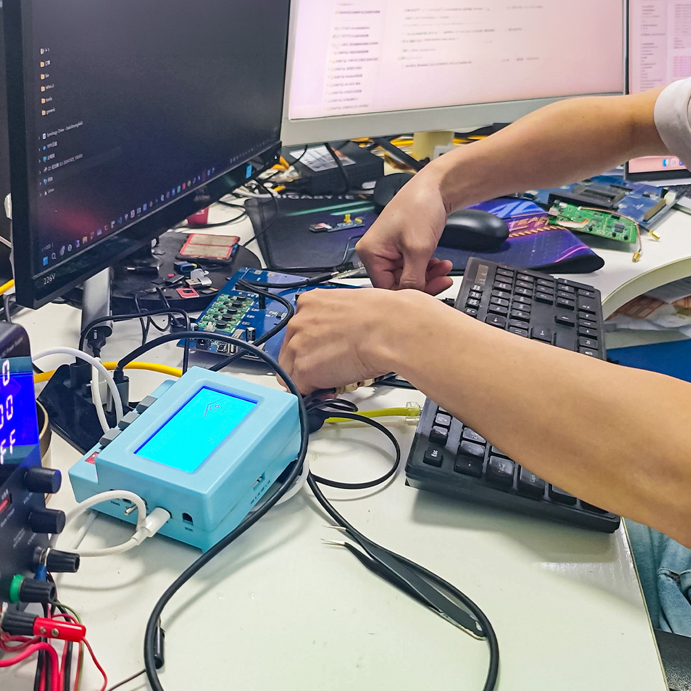 Engineer connecting wires to a testing instrument in GMIC's Shenzhen engineering office